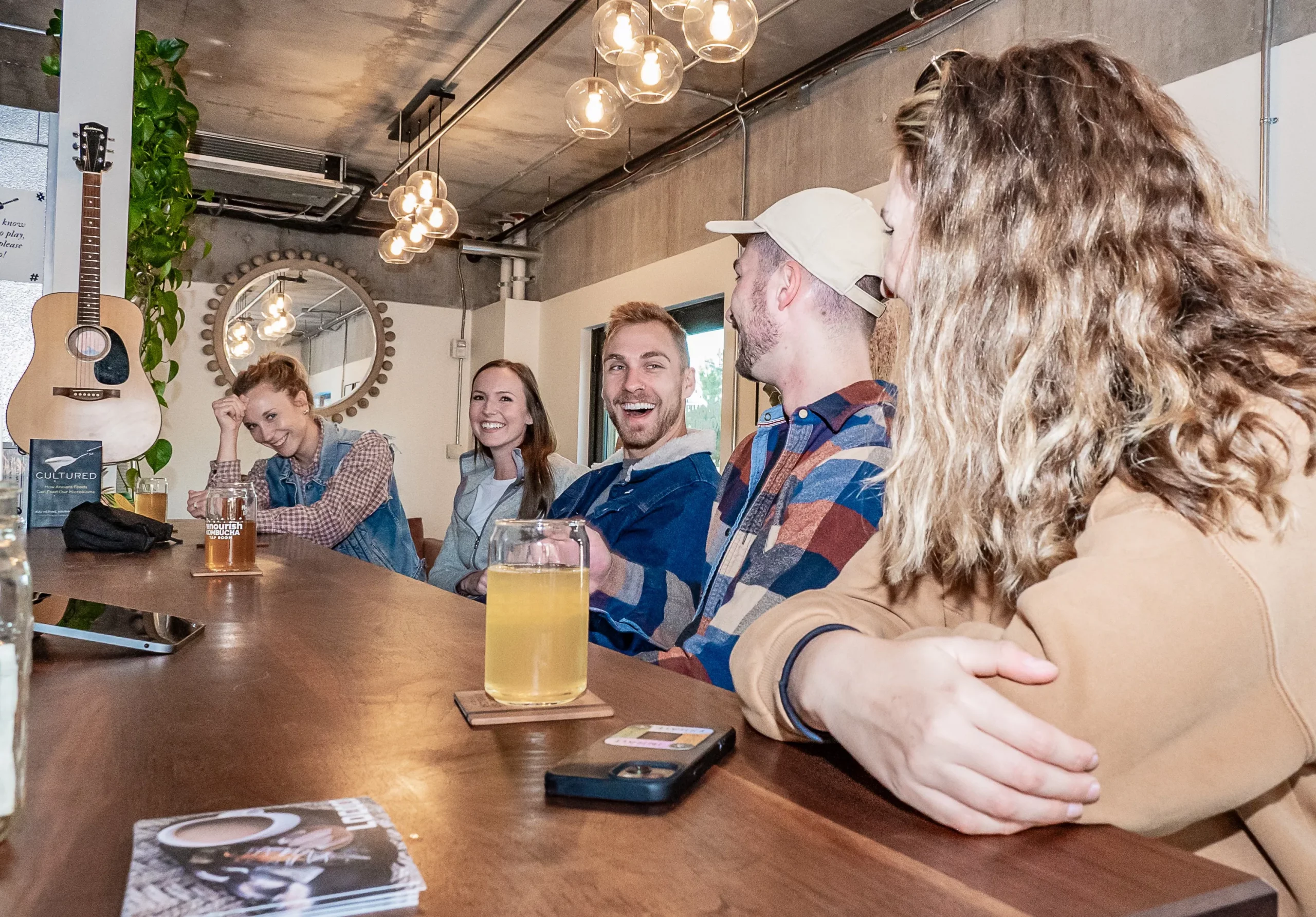 A group of people sitting at a bar, enjoying non-alcoholic drinks.