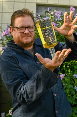 Alan Scott balances a bottle of Fruita Triple Sec on his palm.