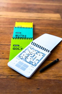 A copy of Paper Apps DUNGEON sits open on top of other Paper Apps series, including GOLF, NUTRITION and TO DO. Photo: Ashley Christenson