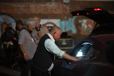 John Woo leans against a car on the set of Silent Night. 