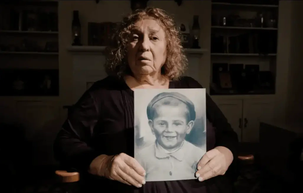 Sarah Rolnick sits in her home, leafing through an old family photo album