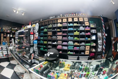 A fish-eye picture of Uprok, showcasing a wall of spray cans, skate gear and hats.