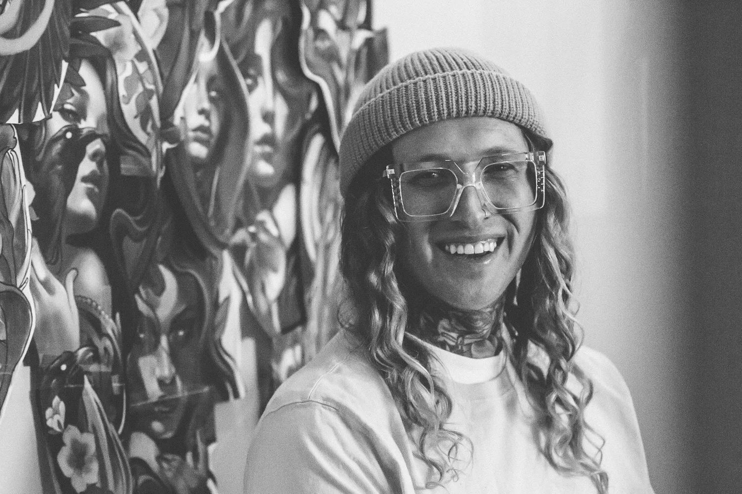 A black and white image of Bobby Johnson standing in front of a mural wall