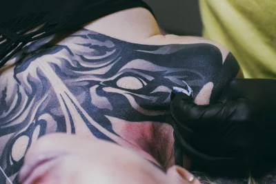 A closeup shot of a black and white chest tattoo.
