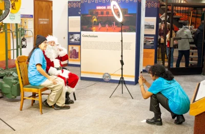 A volunteer poses with Santa at the photo booth.