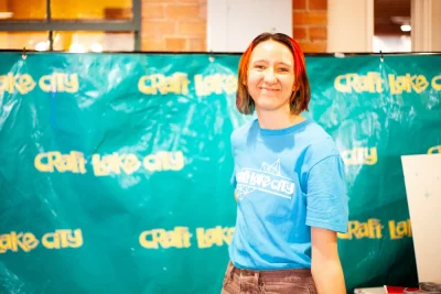 A portrait of a Craft Lake City volunteer in front of a Craft Lake City banner.