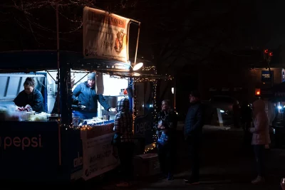 A shopper waits for food at the Greek Oven food truck.