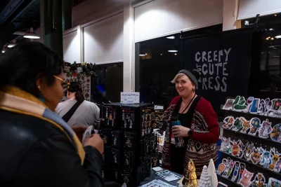 A vendor greets customers at the Creepy but Cute Press booth.