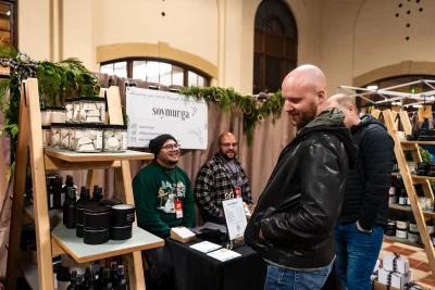 The SoyMurga owners stand at their booth to chat with shoppers.