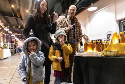 A happy family enjoys samples of Papa Bears Honey.
