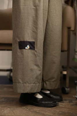 One of Jenson's designs where a small black patch is sewn onto the leg of checked trousers.