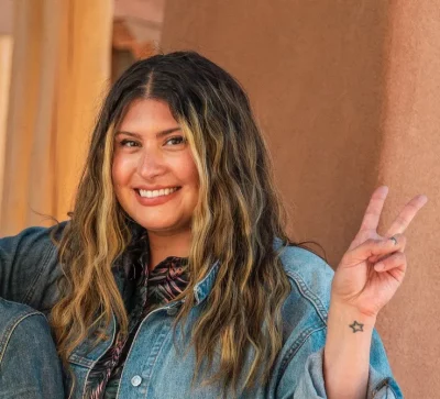 Director Alexandra Lazarowich smiling while holding up a peace sign.