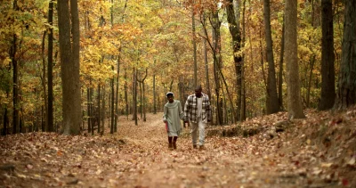 Makayla and Khari Cain walk through a forest.