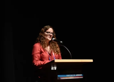Sundance Institute Senior Programmer Heidi Zwicker speaks at a podium.