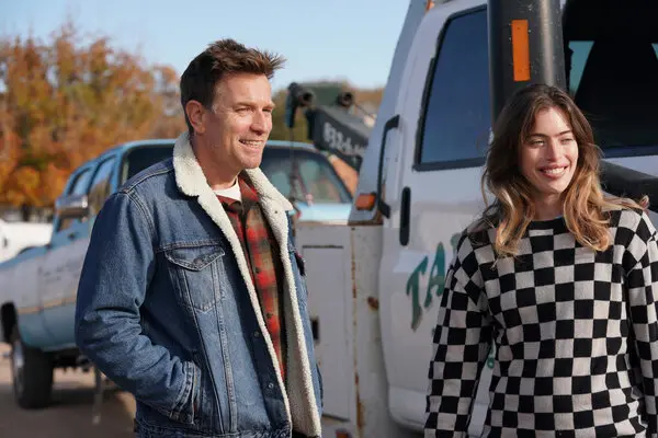 A father and daughter stand in front of a truck together in Bleeding Love.