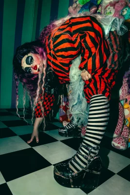 Shortcake touches their toes wearing a striped jumpsuit.