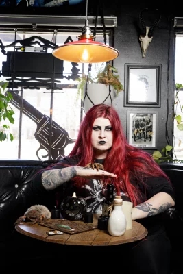 Emily Ard poses with an array of props and a plush spider. 