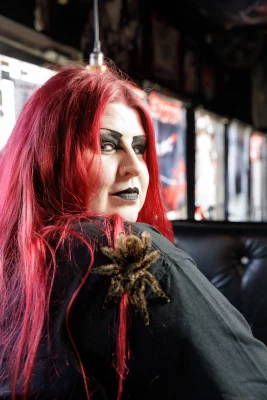 Emily Ard looks over her shoulder with a tarantula resting on it.