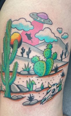 A tattoo by Emily Friend depicting a brightly-colored Western landscape. 