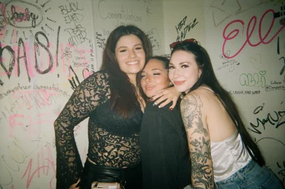 A few girls posing together in the bathroom of a bar.