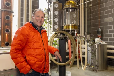 Christensen poses with distillery equipment. 