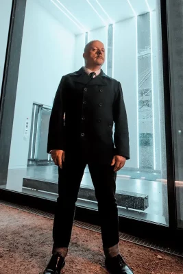 Harris poses next to window in a suit