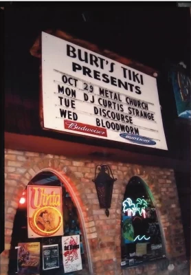 The exterior of Burt's Tiki Lounge, featuring their dimly lit marquee.
