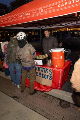 Tony Caputo of Caputo's Market & Deli speaks to two protestors at the red Caputo's tent where he handed out food and drink at the anti-ICE protest at Pioneer Park in Salt Lake City.