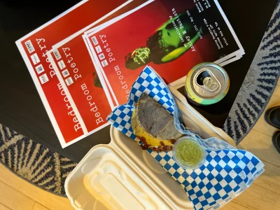 Xolo Masa Co.'s homemade quesadilla in a to-go box surrounded by flyers. 