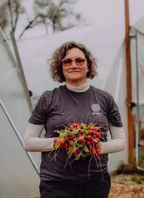 Woman holding a bunch of radishes.