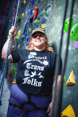 Sunni posing with rope by the rock climbing wall.