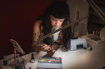 Alia Mathias does her own nails under a light.