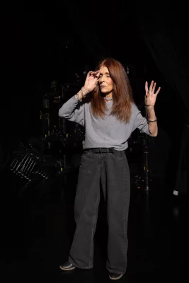 PYGmalion Productions co-founder Reb Fleming imitates acting on-stage in front of a black backdrop.