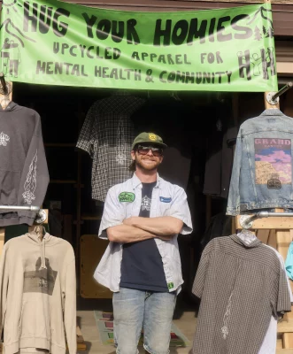 Founder of Hug Your Homies stands in front of his storefront.