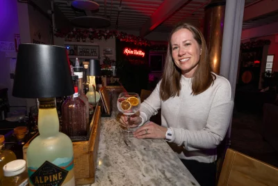 Sara Sergent posing at the bar at Alpine Distilling