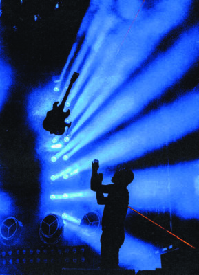A photo by Cassilyn Anderson of rock band Cage the Elephant's guitarist tossing their guitar in the air.