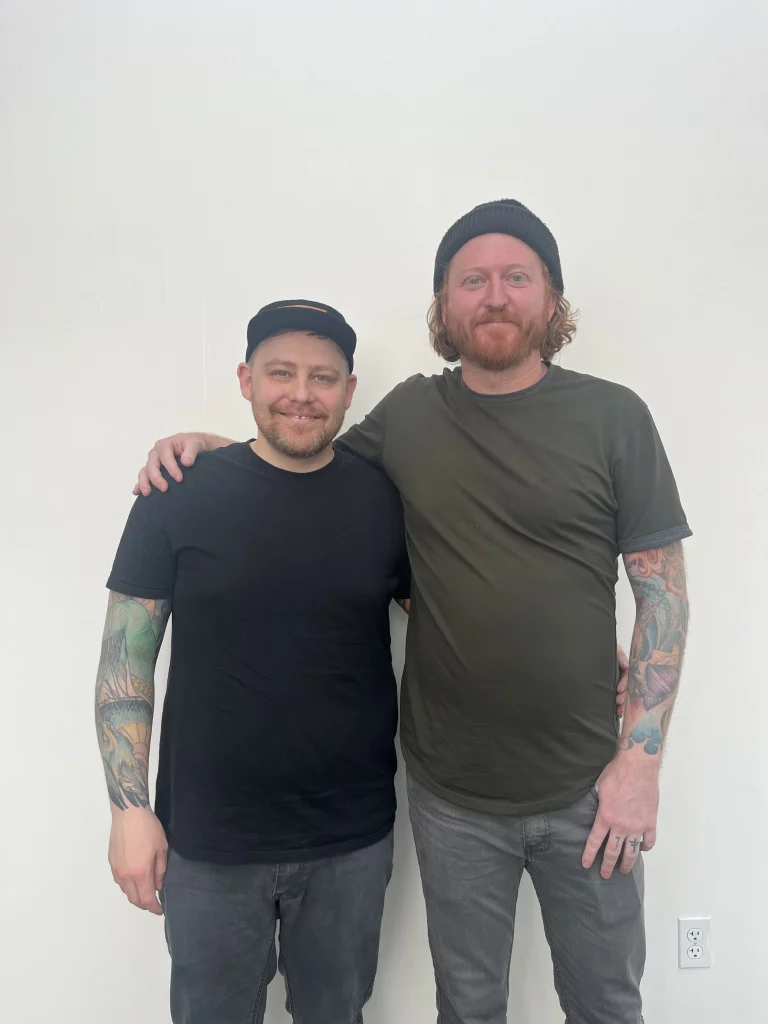 Two men stand together.