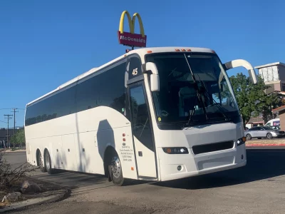 A large touring bus outside of a McDonald's.