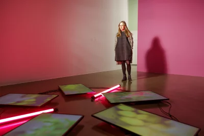 A woman standing in front of an art installation.