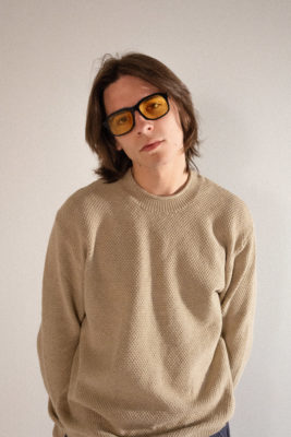A man in a beige sweater modeling Sidecar glasses