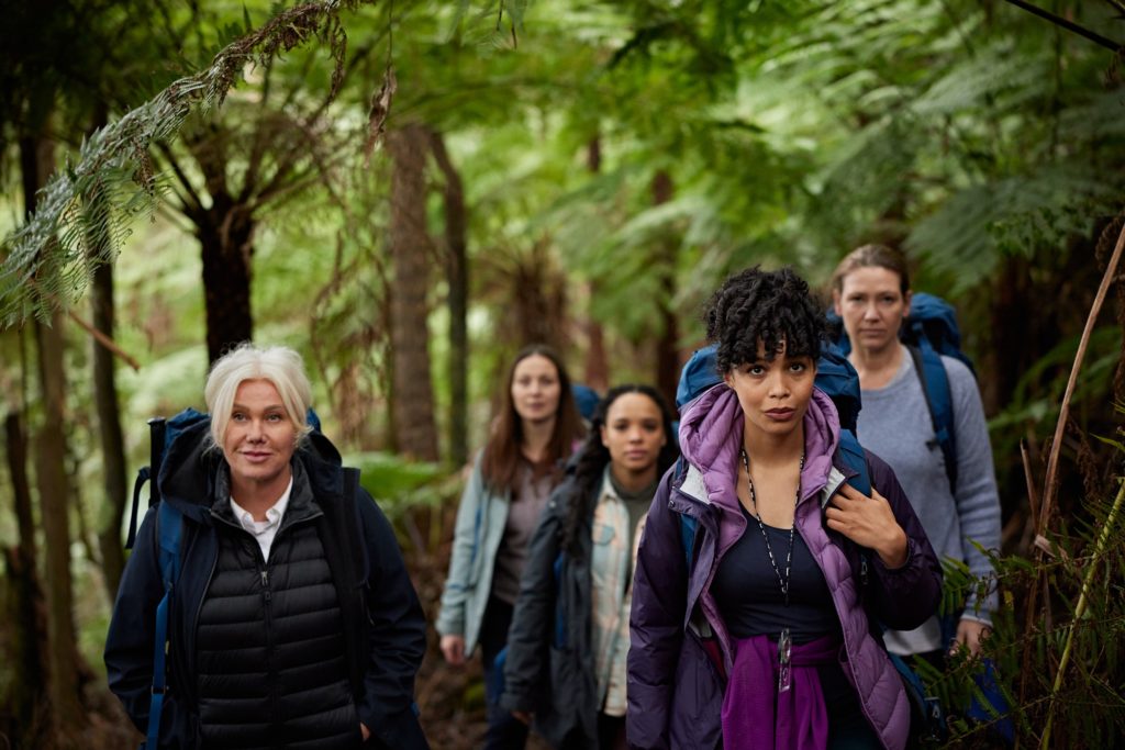 Group of people hiking through a forest.