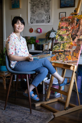 Mercedes Nokyi Ng sitting at her easel