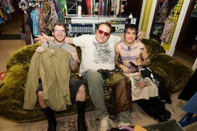 Three guys chilling on a couch while shopping.
