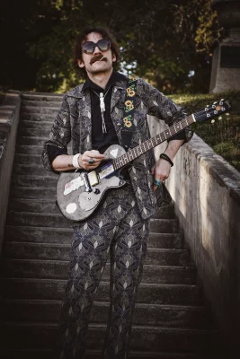 Val in sunglasses with guitar and smoking.