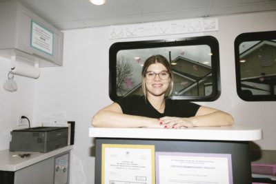Rena Vanzo stands at a counter inside the Boob Bus.