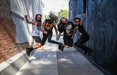 Masculine humans jump with joy in an alleyway.