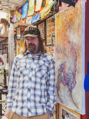 Nate Drew standing in front of some artwork.