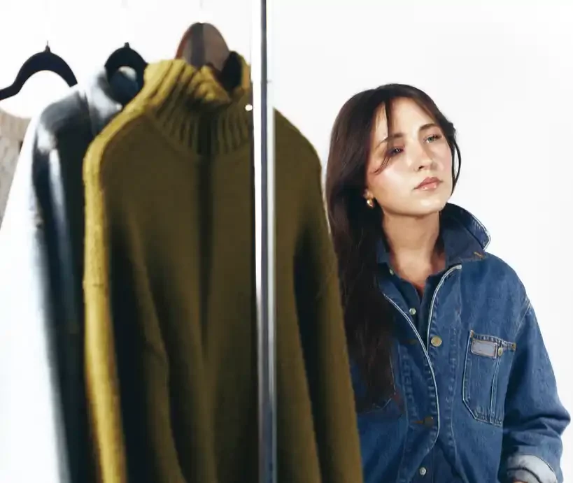 Ellie Fleming stands near a rack of clothing.