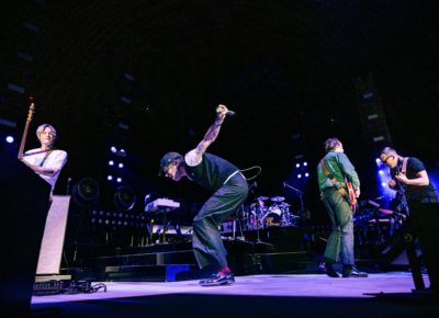 Cage the Elephant playing in Salt Lake City while Matt Shultz crouches and jumpscenter frame, as the other band members play on. Photo: @lmsorenson