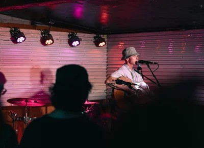 A crowd at the venue Kilby Court surrounding singer-songwriter Quinn Christopherson as he plays on stage.